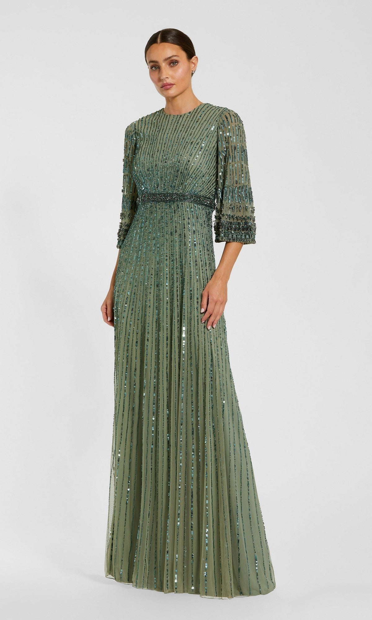 A woman wearing the Mac Duggal 23045 Long Formal Dress in seafoam—a floor-length, modest evening gown featuring three-quarter sleeves, vertical beading, and a fitted waist—stands against a plain light background.